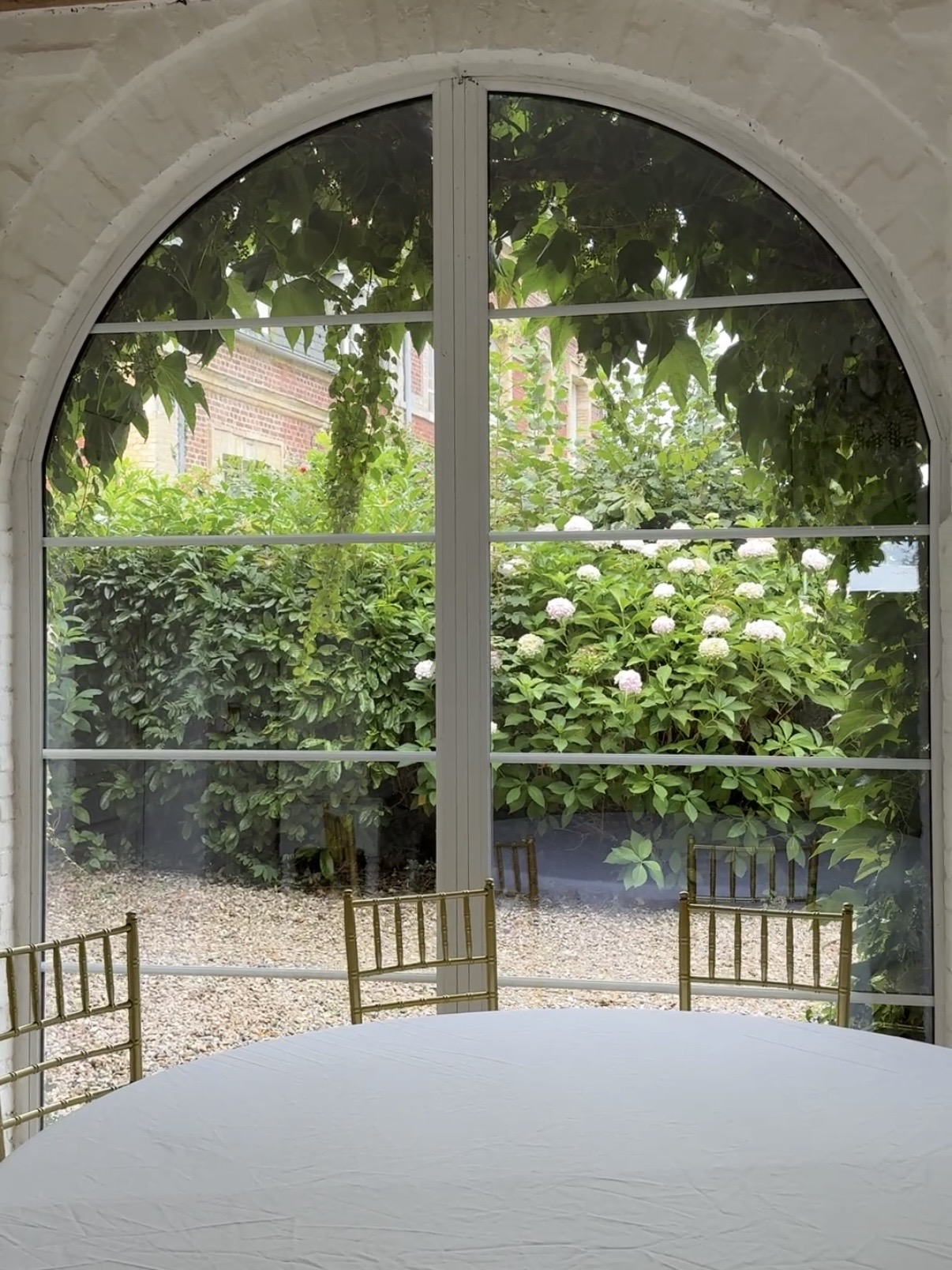The arched window onto the garden, hydrangeas in bloom