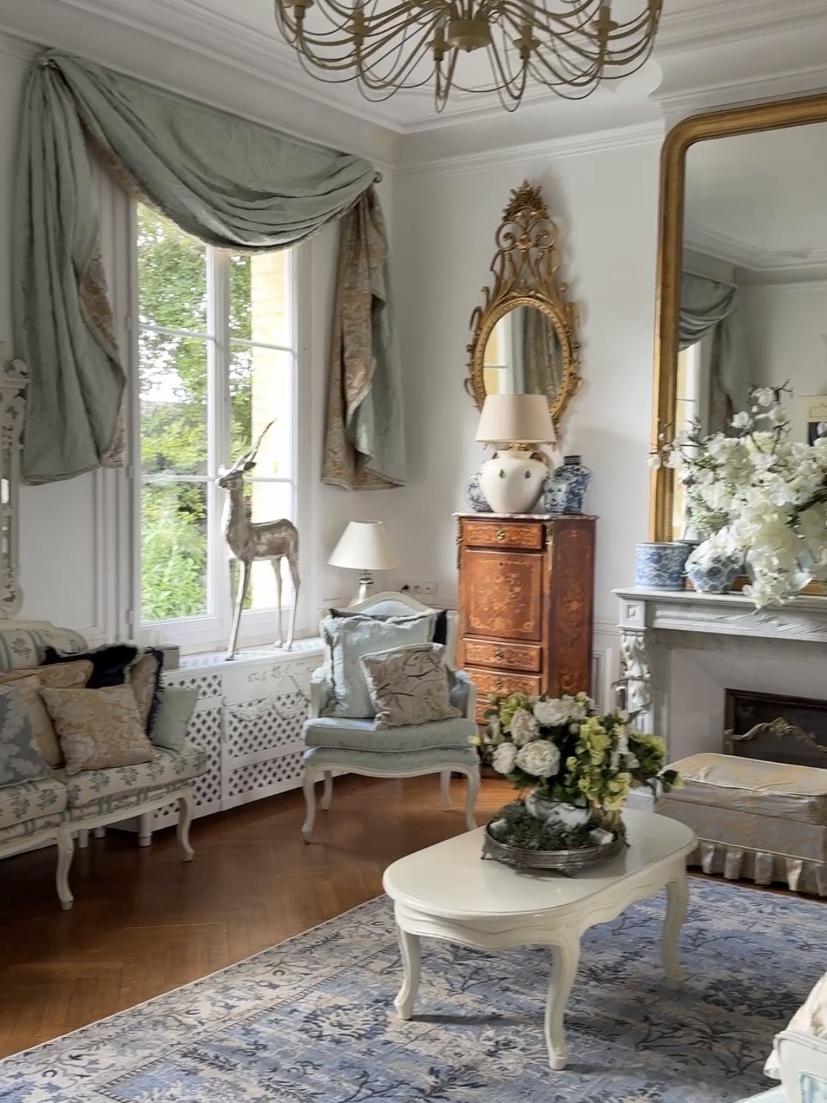 The drawing room — duck-egg drapes, chandelier, gilt mirrors