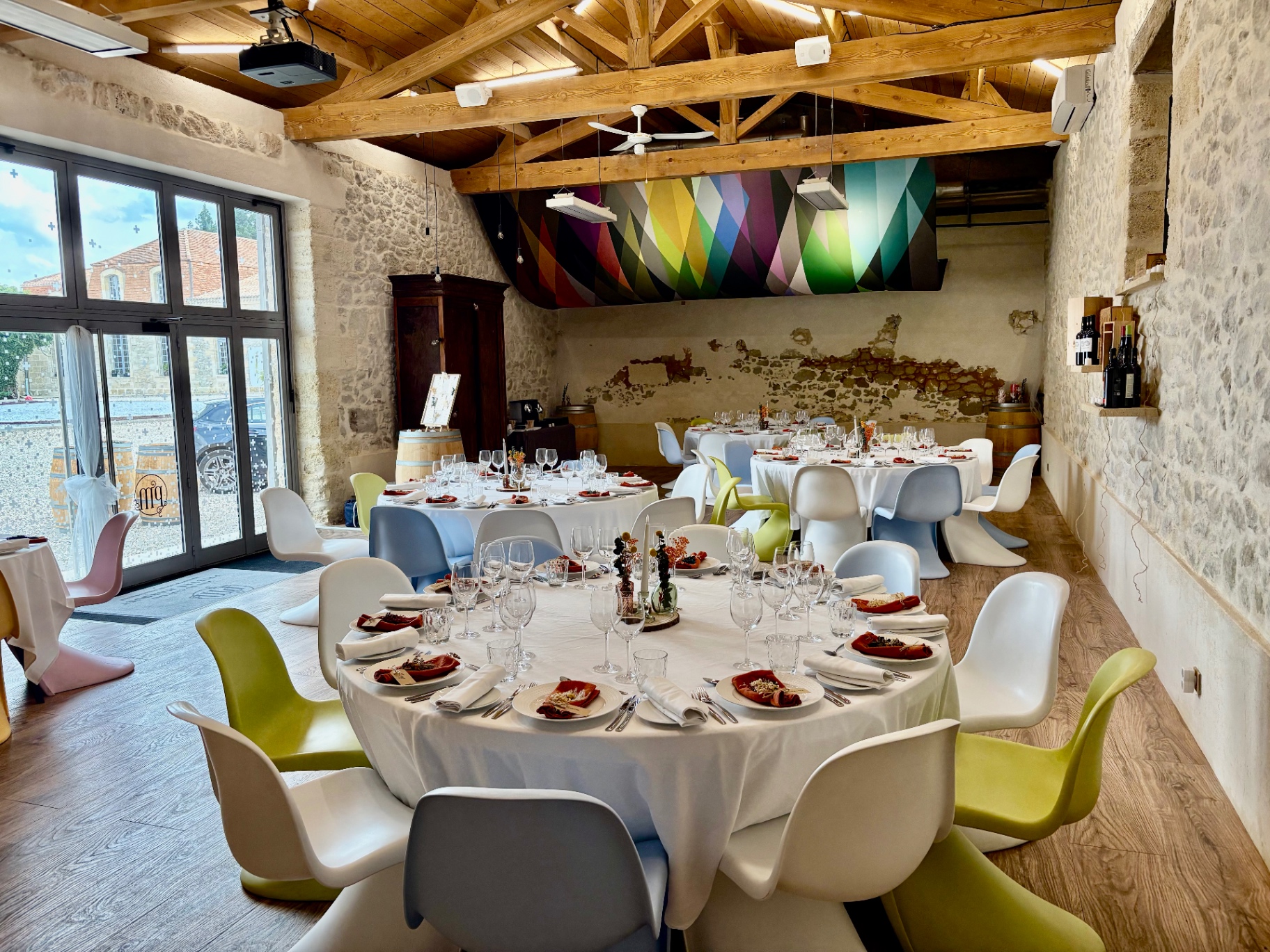Colourful Panton chairs around dressed tables in the chai