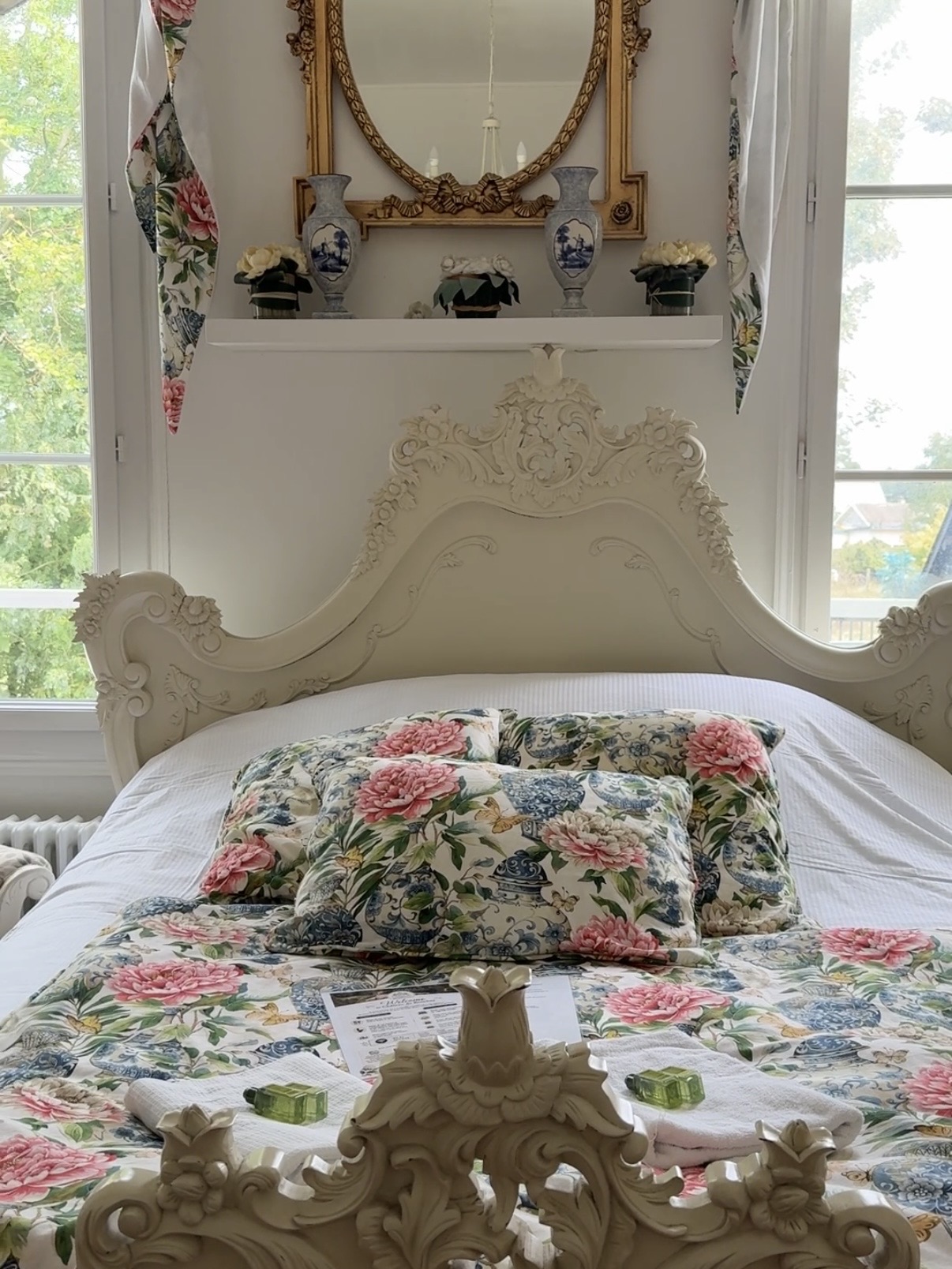 A bedroom in the château — white rococo bed, garden view