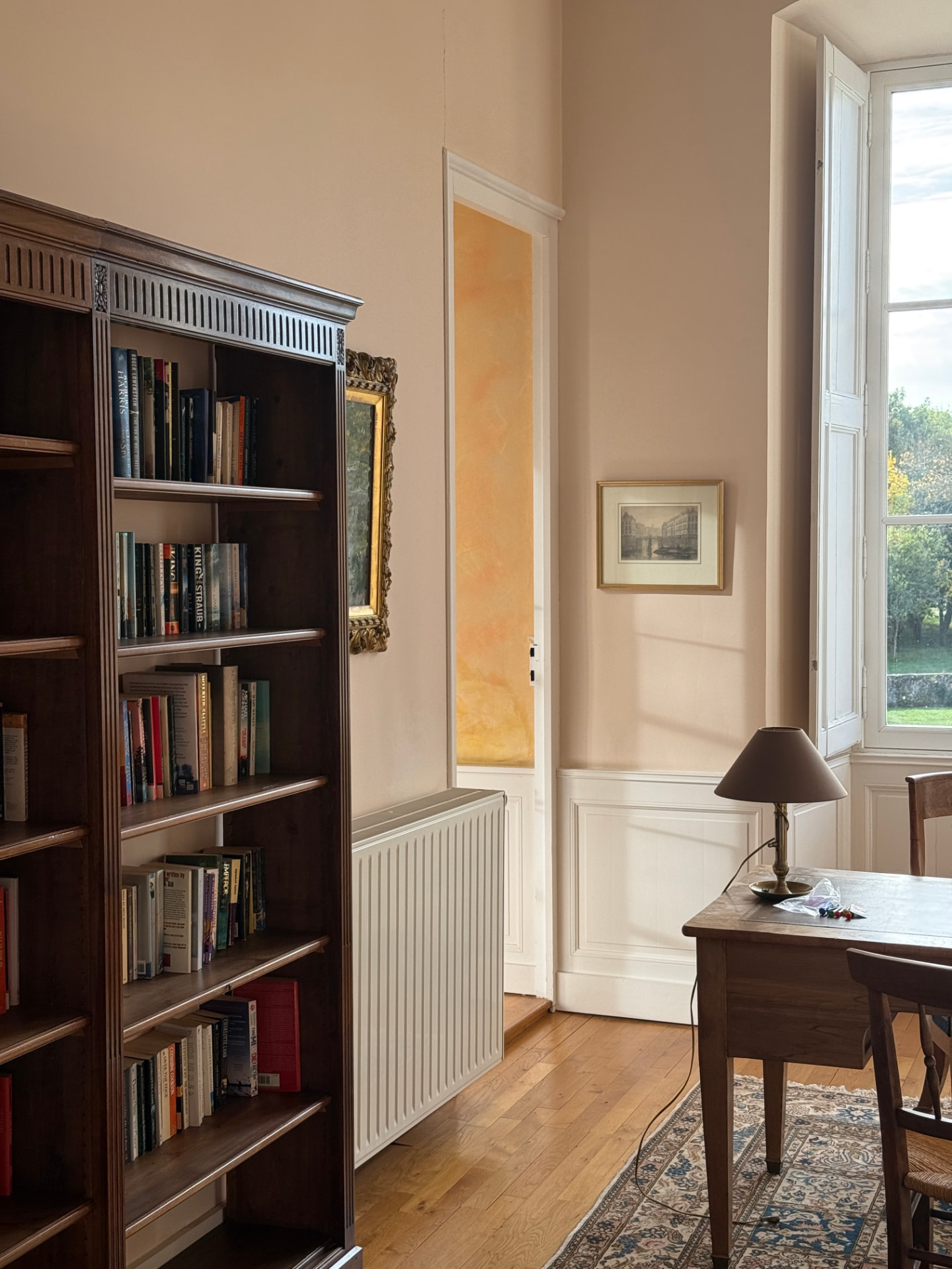 Inside the library — shelves, a writing desk, afternoon light