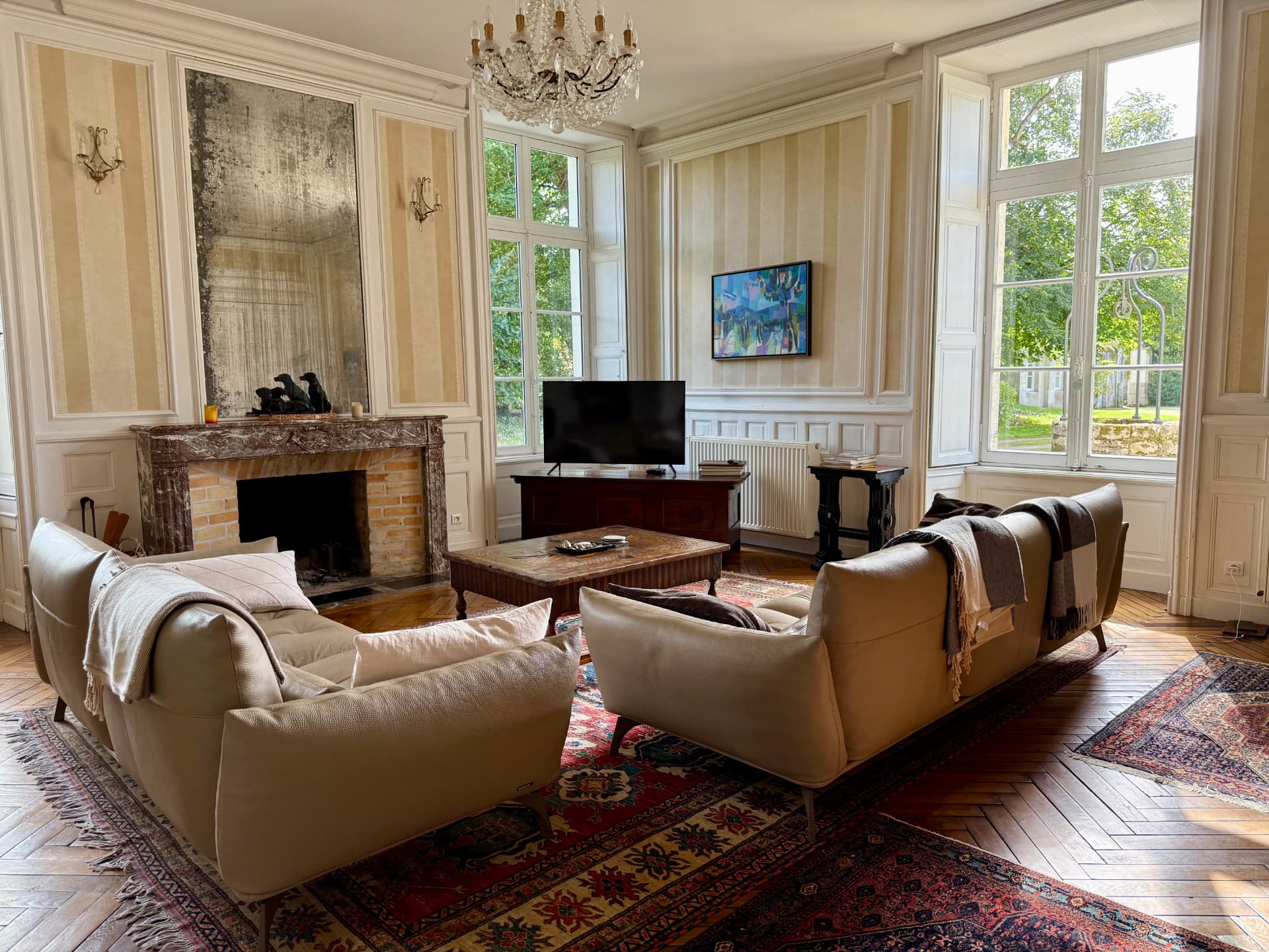 The drawing room — chandelier, marble fireplace, windows open to the park